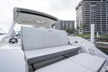  Yacht Photos Pics 2023 Sea Ray SLX 350 Outboard boat with luxurious seating, docked near modern buildings.
