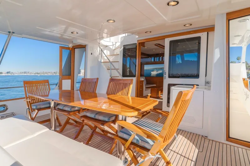 Tintagel Yacht Photos Pics Luxurious 2008 Grand Banks 59 Aleutian RP yacht deck with elegant wooden dining area.