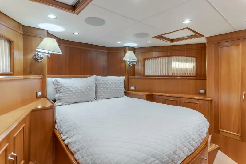Tintagel Yacht Photos Pics Luxurious cabin interior of 2008 Grand Banks 59 Aleutian RP yacht, featuring wood paneling and cozy bedding.