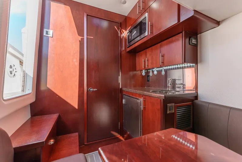 Steam N Demon Yacht Photos Pics Interior of 2019 Buddy Davis 42 CC boat with kitchenette and seating area.