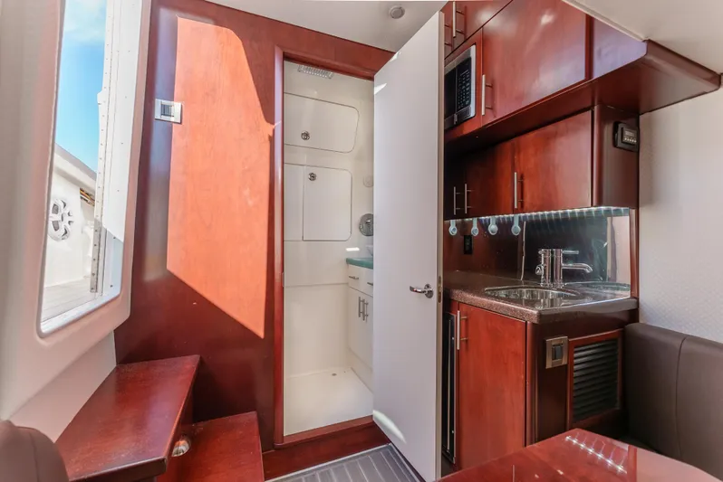 Steam N Demon Yacht Photos Pics Interior of 2019 Buddy Davis 42 CC boat with kitchenette and wooden cabinetry.