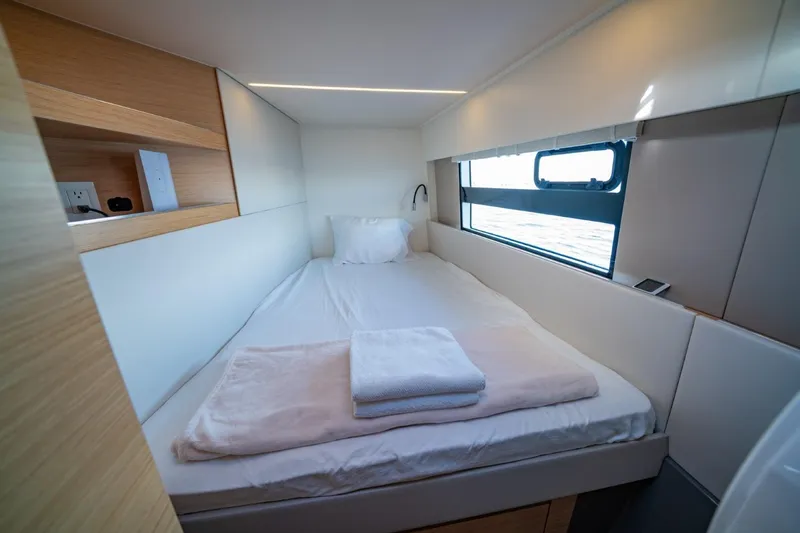 Nostos Yacht Photos Pics Cozy cabin interior of 2020 Nautitech 40 Open catamaran with bed and window view.
