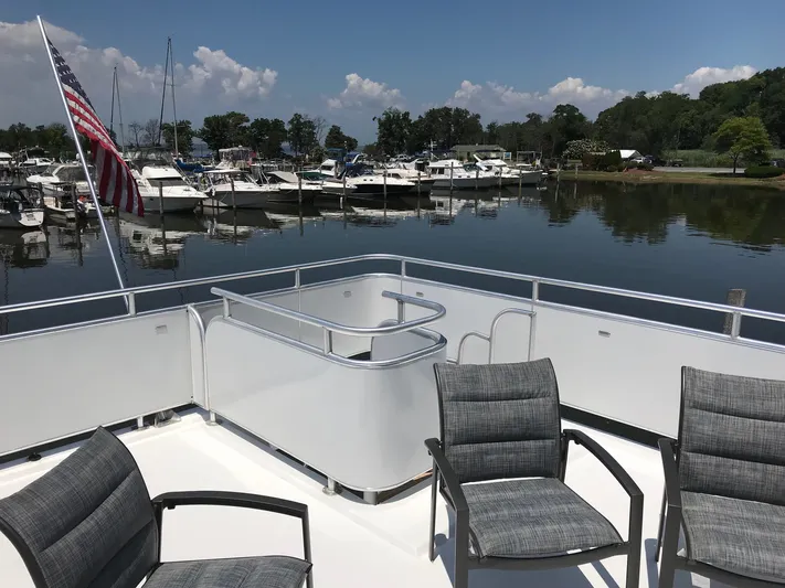 St. Somewhere Yacht Photos Pics 2017 Sumerset houseboat deck with chairs, American flag, and marina view.