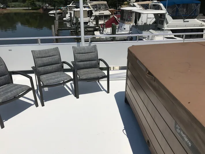 St. Somewhere Yacht Photos Pics Rooftop deck of 2017 Sumerset houseboat with chairs and hot tub, overlooking marina.