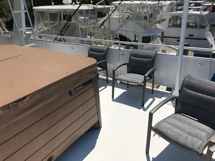 St. Somewhere Yacht Photos Pics 2017 Sumerset houseboat deck with hot tub and chairs, docked at marina.