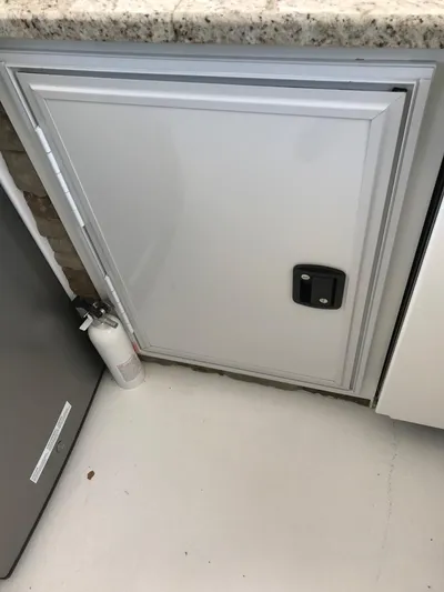 St. Somewhere Yacht Photos Pics White cabinet door on 2017 Sumerset houseboat, granite countertop, fire extinguisher nearby.