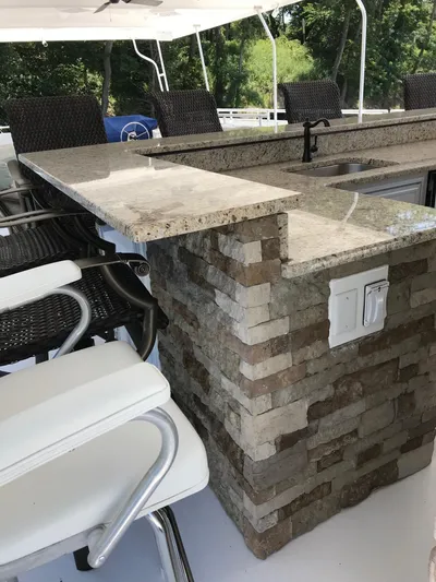 St. Somewhere Yacht Photos Pics Luxurious 2017 Sumerset houseboat bar area with stone counter and wicker chairs.