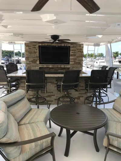 St. Somewhere Yacht Photos Pics Luxurious 2017 Sumerset houseboat interior with seating, bar stools, and mounted TV.