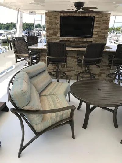 St. Somewhere Yacht Photos Pics Luxurious 2017 Sumerset houseboat interior with cushioned seating, round table, and mounted TV.