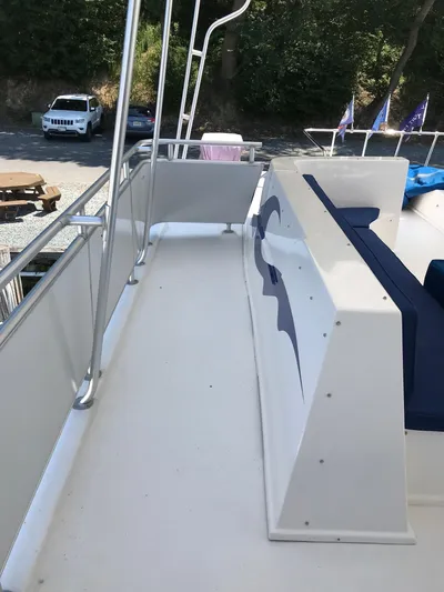 St. Somewhere Yacht Photos Pics 2017 Sumerset houseboat deck with railing, parked cars, and trees in the background.
