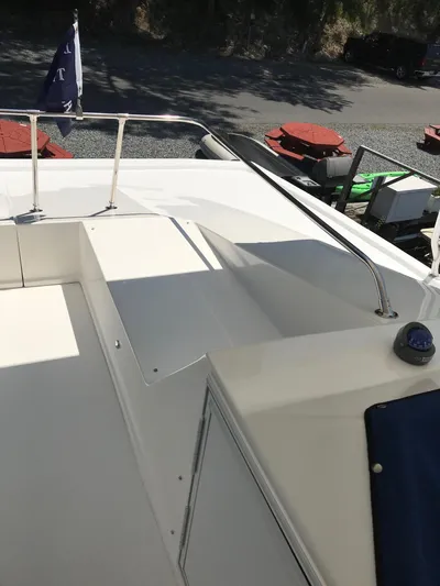 St. Somewhere Yacht Photos Pics 2017 Sumerset houseboat deck with railing and flag, docked near outdoor furniture.