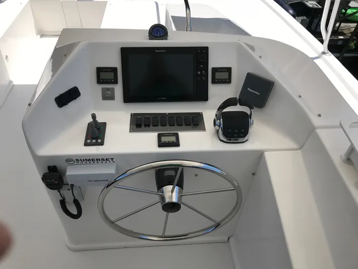 St. Somewhere Yacht Photos Pics 2017 Sumerset Houseboat helm with steering wheel, navigation controls, and electronic display.