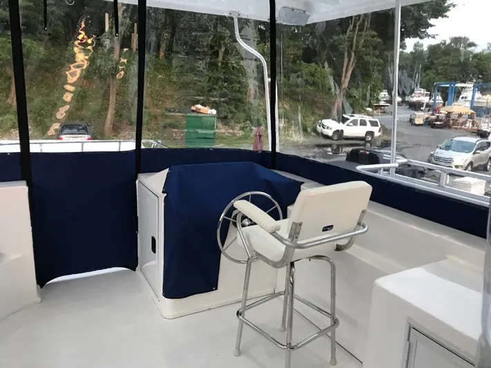 St. Somewhere Yacht Photos Pics 2017 Sumerset houseboat helm with blue cover and white captain's chair, dockside view.