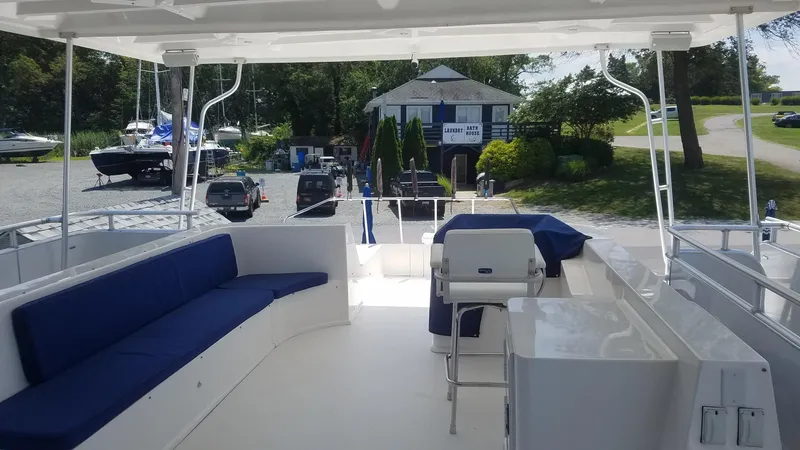 St. Somewhere Yacht Photos Pics 2017 Sumerset houseboat interior with blue seating, docked near a marina.