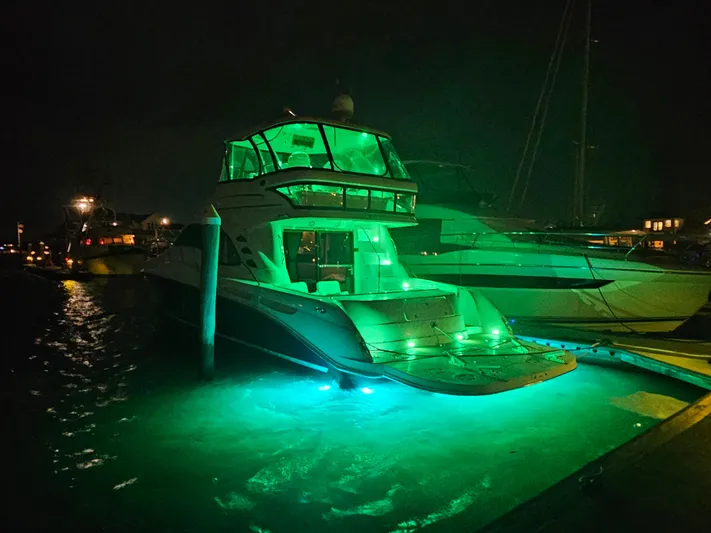  Yacht Photos Pics 2006 Sea Ray 580 Sedan Bridge yacht illuminated with green lights at night.