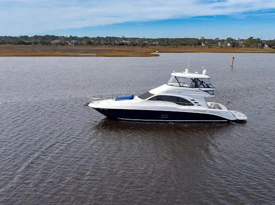  Yacht Photos Pics 2006 Sea Ray 580 Sedan Bridge yacht cruising on calm waters under a clear sky.