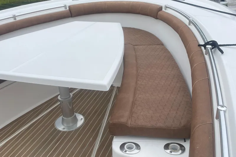 My Buddy Yacht Photos Pics 2016 Buddy Davis 28 Center Console boat interior with cushioned seating and table.