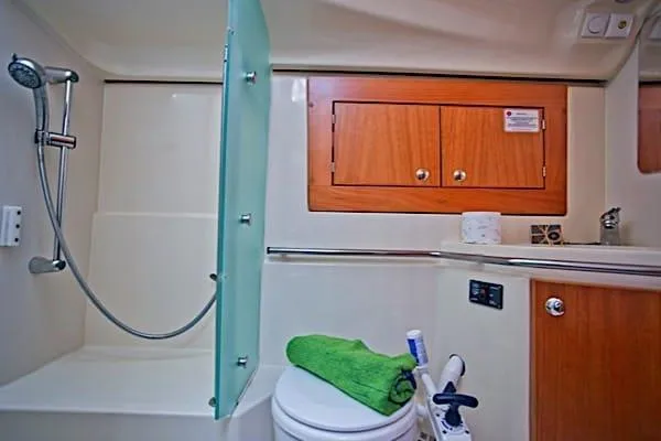 Aventura Yacht Photos Pics Bathroom interior of 2008 Elan Impression yacht with shower, toilet, and wooden cabinets.