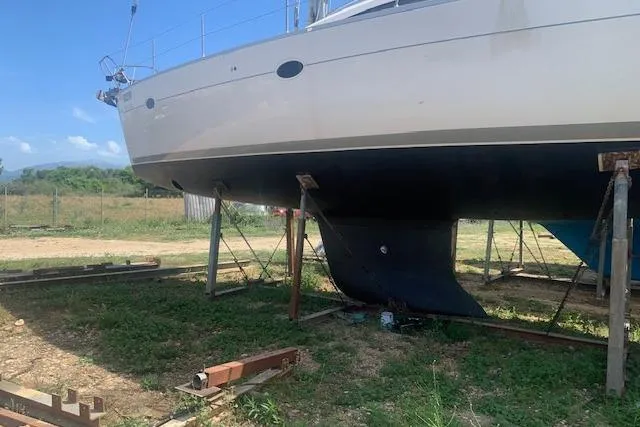 Aventura Yacht Photos Pics 2008 Elan Impression yacht on dry dock, supported by stands, grassy area, clear sky.