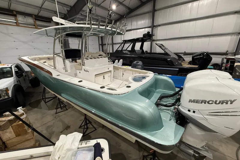  Yacht Photos Pics 2021 Mag Bay 33 CC boat with Mercury engine in a storage facility.