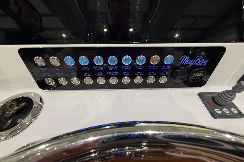  Yacht Photos Pics Control panel of 2021 Mag Bay 33 CC boat with illuminated switches and brand logo.