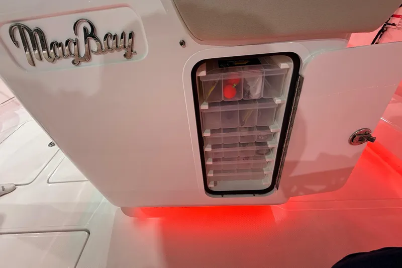  Yacht Photos Pics 2021 Mag Bay 33 CC boat storage compartment with organized tackle boxes and red LED lighting.