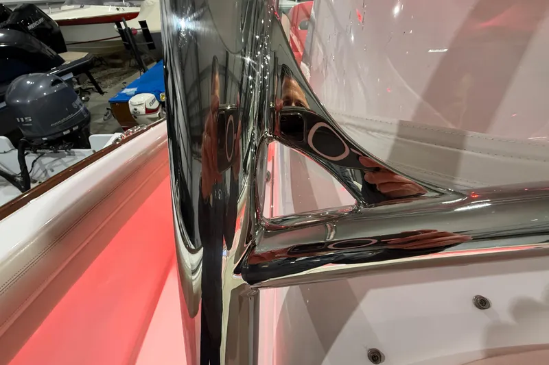  Yacht Photos Pics Close-up of 2021 Mag Bay 33 CC's polished metal detail in a boat showroom.