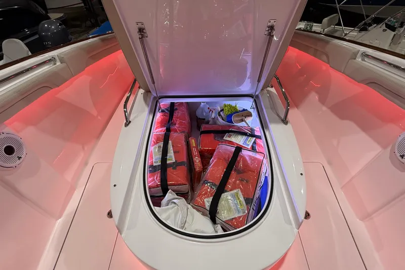  Yacht Photos Pics 2021 Mag Bay 33 CC boat storage compartment with life jackets and red ambient lighting.