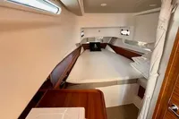 2023 Nimbus T 11 cabin interior with cozy bed and wooden accents.