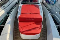 2023 Nimbus T 11 yacht with red seating, docked in a marina, surrounded by mountains.