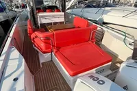 2023 Nimbus T 11 boat with red seating, docked in a marina under clear blue skies.