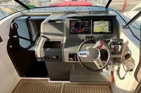Interior of 2023 Nimbus T 11 boat with modern dashboard and red seating.