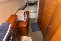 2023 Nimbus T 11 cabin interior with wood finish, microwave, and bed.