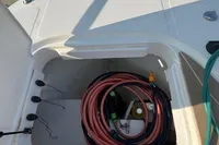 Storage compartment on a 2023 Nimbus T 11 boat with coiled hoses.