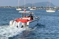 Nimbus T 11 boat cruising on a scenic lake with sailboats in the background.