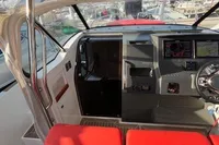 Interior of 2023 Nimbus T 11 boat with red seating and modern dashboard.