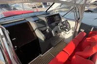 2023 Nimbus T 11 boat cockpit with red seating and modern navigation controls.