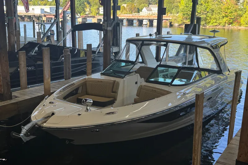  Yacht Photos Pics 2020 Sea Ray SLX 350 boat docked in a marina, surrounded by water and wooden posts.