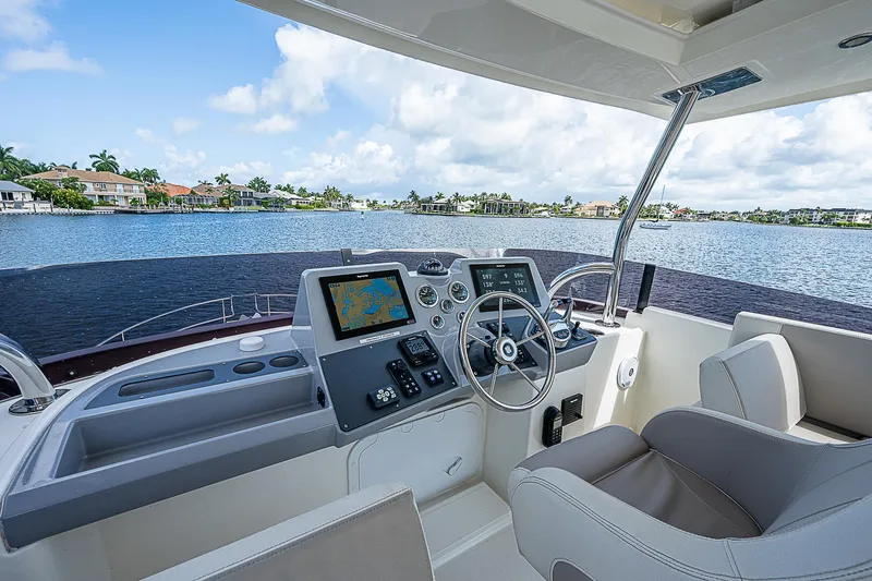 Horizon IV Yacht Photos Pics 2020 Beneteau Swift Trawler 47 helm with navigation screens, steering wheel, and waterfront view.
