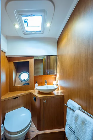 Horizon IV Yacht Photos Pics 2020 Beneteau Swift Trawler 47 bathroom with wood finish and skylight.