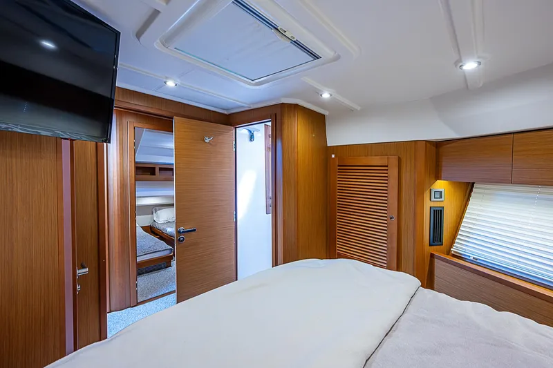 Horizon IV Yacht Photos Pics Interior of 2020 Beneteau Swift Trawler 47, featuring a cozy bedroom with wood paneling.