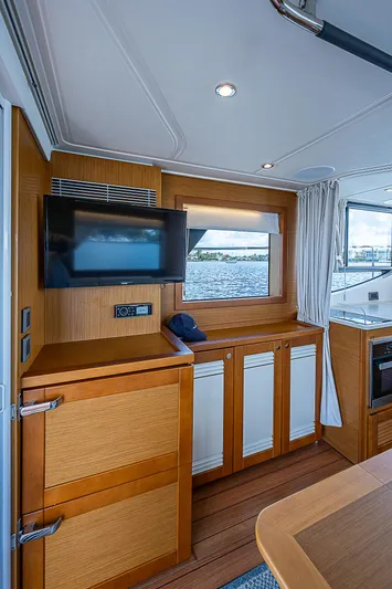 Horizon IV Yacht Photos Pics 2020 Beneteau Swift Trawler 47 interior with wood cabinetry and mounted TV.