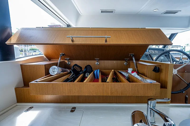 Horizon IV Yacht Photos Pics 2020 Beneteau Swift Trawler 47 kitchen storage with open wooden cabinet and organized compartments.