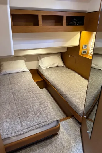 Horizon IV Yacht Photos Pics 2020 Beneteau Swift Trawler 47 cabin with twin beds and wooden storage shelves.