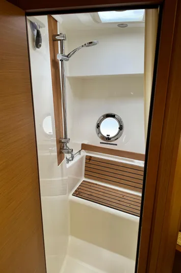Horizon IV Yacht Photos Pics 2020 Beneteau Swift Trawler 47 shower area with wooden bench and porthole window.
