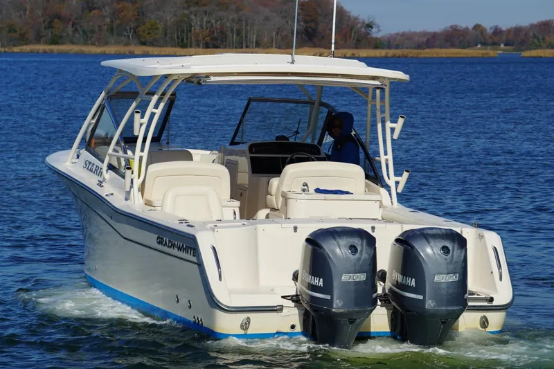 Starr Yacht Photos Pics 2015 Grady-White Freedom 307 boat with dual Yamaha engines on a serene lake.