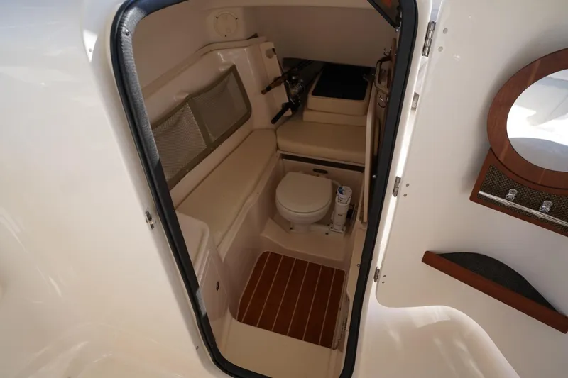 Starr Yacht Photos Pics 2015 Grady-White Freedom 307 boat interior with compact bathroom and wooden accents.