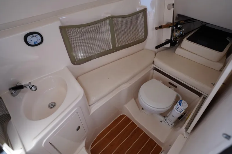 Starr Yacht Photos Pics 2015 Grady-White Freedom 307 boat interior with sink, toilet, and seating area.