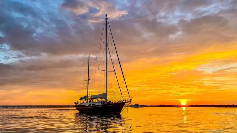  Yacht Photos Pics 1984 Irwin Cutter Ketch sailing at sunset with vibrant sky and calm waters.