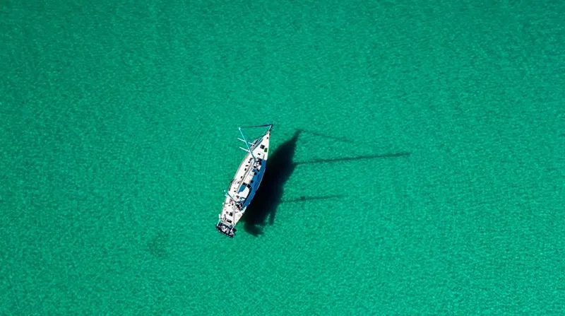  Yacht Photos Pics Aerial view of 1984 Irwin Cutter Ketch sailboat on clear turquoise water.